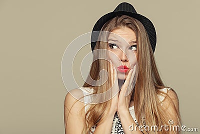 Surprised happy beautiful young woman looking up in excitement. Fashion girl in hat Stock Photo