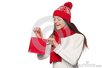 Surprised happy woman holding and looks in red bag in excitement, shopping. Christmas girl on winter sale with gift, isolated Stock Photo