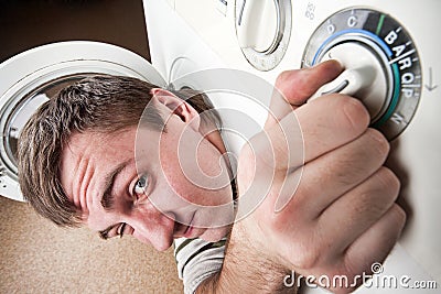 Surprised man inside washing machine Stock Photo