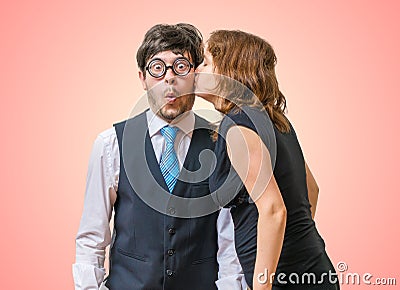 Surprised nerd is being kissed by pretty woman Stock Photo