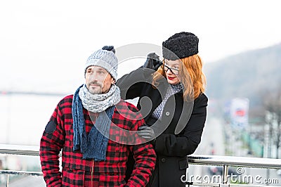 Surprised red hair woman in glasses looked at stranger on bridge. Woman look over the glasses from the man back. Stock Photo