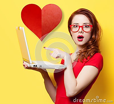 Surprised redhead girl with laptop and heart Stock Photo