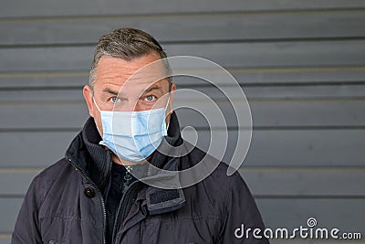 Surprised or sceptical middle-aged man wearing a face mask Stock Photo
