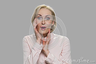 Surprised stunned woman on gray background. Stock Photo