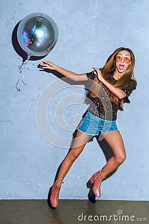 surprised stylish african american girl with shiny balloon looking Stock Photo