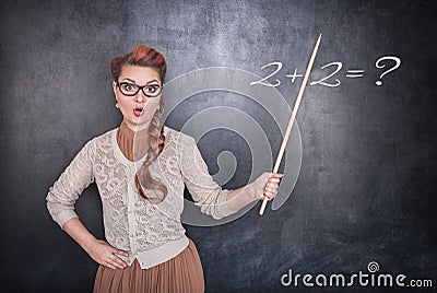 Surprised teacher with pointer on chalkboard background Stock Photo