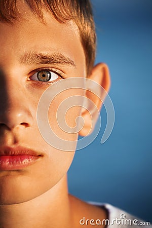 Surprised teenager boy against sea, half of face Stock Photo