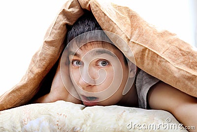 Surprised Teenager Under Blanket Stock Photo