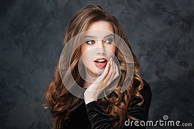 Surprised tender young woman with beautiful curly hair Stock Photo