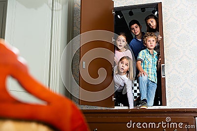 Tweens peeking into quest room through open door Stock Photo
