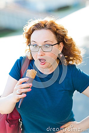 Surprised woman in blue T-shirt looking on ice cream cone Stock Photo