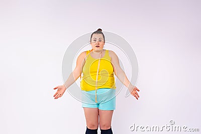 The surprised woman with a centimeter spread her arms out to the sides. Surprised by the size of the abdomen. Obesity Stock Photo