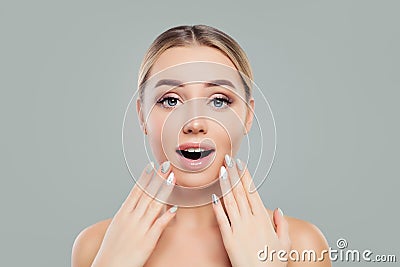 Surprised woman with opened mouth. Happy girl with healthy clear skin and manicured hands. Facial treatment Stock Photo