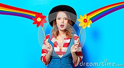 Surprised woman with pinwheel and rainbow Stock Photo