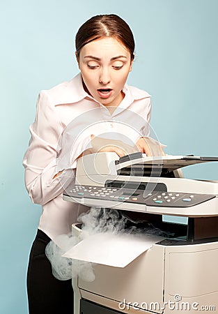 Surprised woman with smoking copier Stock Photo