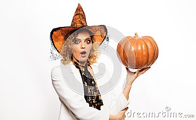 Surprised woman in witch hat with pumpkin. Preparation Halloween holidays. Stock Photo