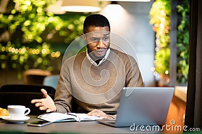 Surprised young black manager looking at his computer Stock Photo