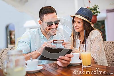 Surprised young couple doing online shopping through digital tablet Stock Photo