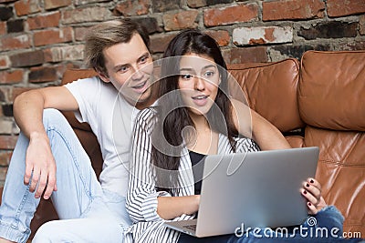 Surprised couple looking at laptop amazed by unbelievable online Stock Photo