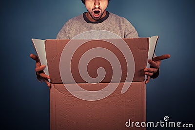 Surprised young man opening exciting box Stock Photo