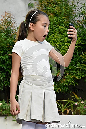 Surprised Young Philippina Female With Phone Stock Photo