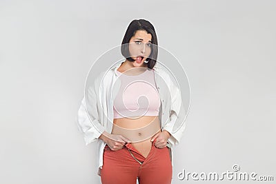 Surprised young woman cannot wear summer pants. Diet, overweight, obesity concept Stock Photo