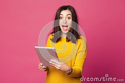 Surprised young woman holding tablet computer Stock Photo