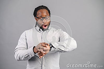 Surprized African-American man is late isolated on grey Stock Photo