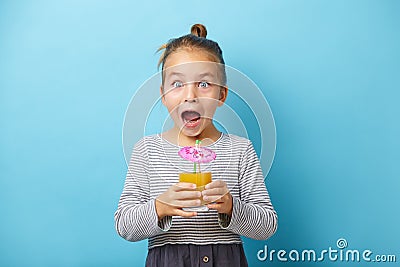 Surprized little girl with orange juice in hands. Stock Photo