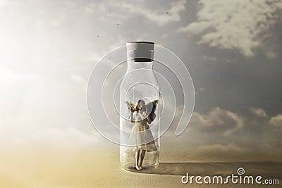 Surreal butterfly woman looks at freedom enclosed in a bottle Stock Photo