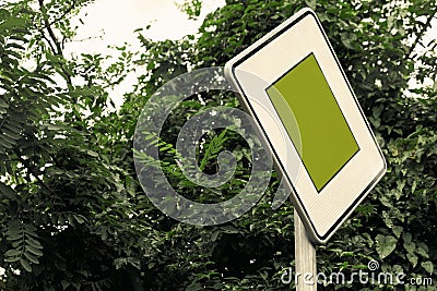 Surreal green color traffic sign concept with lush foliage - social issues concept with copy space. Close-up of right of way sign. Stock Photo
