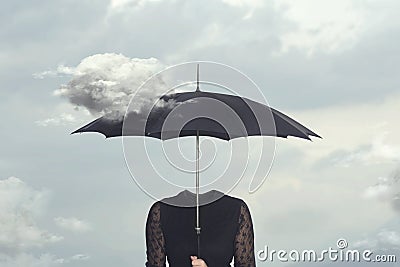 Surreal moment of a cloud caressing the umbrella of a headless woman Stock Photo