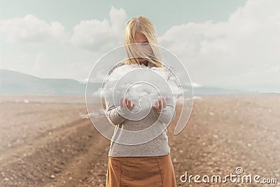 Surreal moment of a woman holding a cloud in her hands Stock Photo