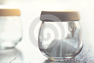 Surreal moment of a woman inside a glass jar Stock Photo