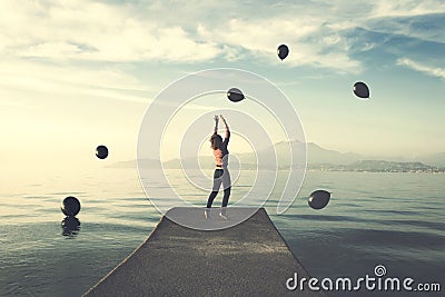 Surreal moment, woman tries to taking the black balloons that rain from the sky Stock Photo