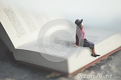 Surreal moment of a woman relaxes sitting on a giant book Stock Photo