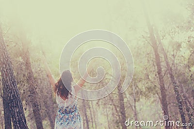 Surreal photo of young woman standing in forest. image is textured and toned. dreamy concept Stock Photo