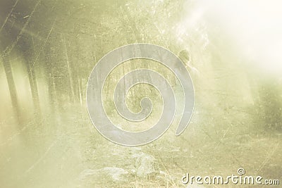 Surreal photo of young woman standing in forest. image is textured and toned. dreamy concept. Stock Photo