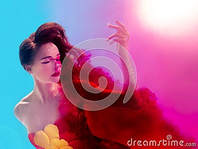 Surreal portrait of young attractive woman with air bubbles underwater in colorful water with ink Stock Photo