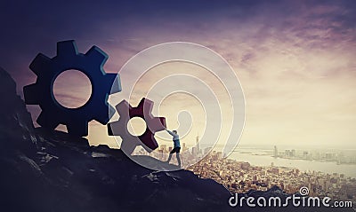 Surreal scene determined businessman pushing big cog wheels uphill. Business concept, hard working for purpose fulfilling and Stock Photo