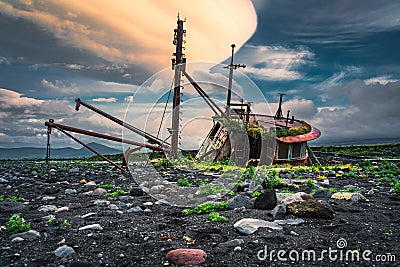 Surreal sunrise casts its light on an abandoned fishing boat in Umnak, Alaska Stock Photo