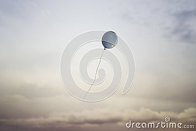 Surreal travel of a balloon flying in the sky towards freedom, concept of lightness of the spirit of dreamers Stock Photo