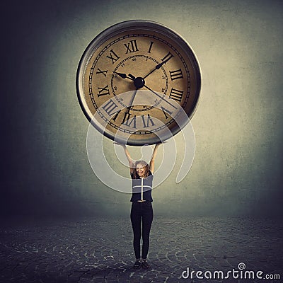 Surreal view as a tiny girl teenager lifting a huge clock over head. Student time management concept. Educational process hours, Stock Photo