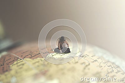 Surreal woman looks at a destination for her journey in a giant globe Stock Photo