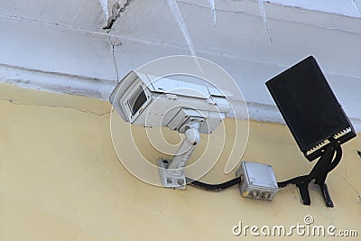 Surveillance camera mounted on tiled wall of house Editorial Stock Photo