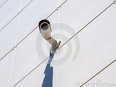 Surveillance camera mounted on a wall lined with ceramic tiles Stock Photo