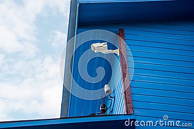 Surveillance camera on wall of a wooden house Stock Photo