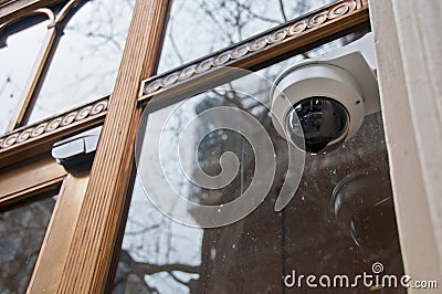 Surveillance CCTV security dome camera near office window in Europe Stock Photo