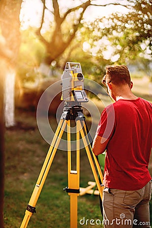 surveyor caucasian engineer working with total station theodolite at landscaping project Stock Photo
