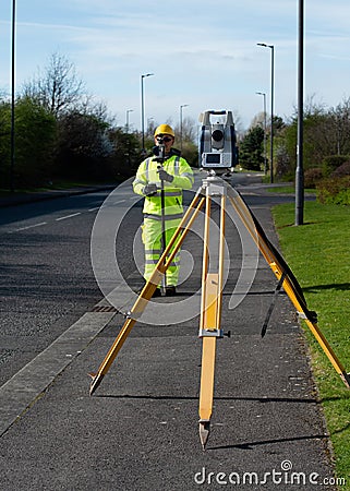 Surveyor doing road survey using modern robotic total station EDM before beginning of construction works Stock Photo